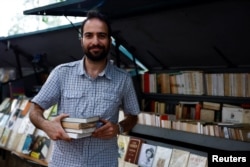 Newly Parisian bouquiniste, traditional street bookseller, Rachid Bouanou poses during an interview with Reuters, along the banks of the River Seine in Paris, France, August 18, 2022. REUTERS/Sarah Meyssonnier