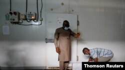 A worker prepares to store boxes of vaccines in a cold room as the country receives its first batch of coronavirus disease (COVID-19) vaccines under COVAX scheme, in Accra, Feb. 24, 2021.