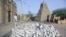 In this May 1, 2012 photo, men work alongside one of Timburktu's historic mud mosques in Mali. 