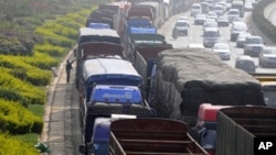 FILE - Vehicles line up for diesel near a gas station in Kunming, Yunnan province, China.
