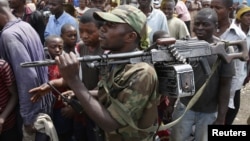 A M-23 rebel fighter walks with his rifle as the group withdraws from the eastern Congolese city of Goma, December 1, 2012.