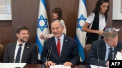 Israeli Prime Minister Benjamin Netanyahu (C) and Minister of Finance Bezalel Smotrich (L) attend a weekly cabinet meeting in the prime minister's office in Jerusalem, on June 18, 2023.