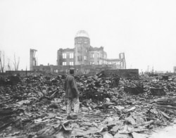 FILE - In this 1945 file photo, an Allied war correspondent stands in the ruins of Hiroshima, Japan, just weeks after the city was leveled by an atomic bomb.