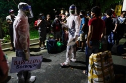 Bus workers fetch families, workers and students who were stranded at the capital when the community lockdown was implemented to give them a free ride back to their province in Baclaran, Metro Manila, Philippines, May 29, 2020.