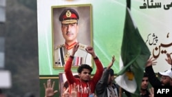 Supporters of the hardliner Tehreek e Labbaik Pakistan (TLP) party take part in a protest rally in front of a picture of Pakistan's Army Chief General Syed Asim Munir in Lahore, Feb. 10, 2024 amid claims the election result delay is allowing authorities to rig the vote-counting. 