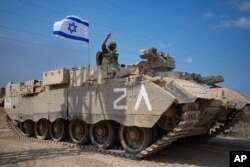 Seorang tentara Israel mengacungkan tanda V saat menuju perbatasan Jalur Gaza di Israel selatan, Sabtu, 14 Oktober 2023. (Foto: AP/Ariel Schalit)