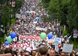 FILE - People hold various posters supporting Khabarovsk region's governor Sergei Furgal, during an unsanctioned protest in support of Sergei Furgal, who was interrogated and ordered to be held in jail for two months, in Khabarovsk.