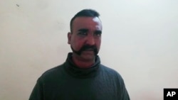 An image taken from video released by Pakistan's military, shows what Pakistan claims to be an Indian pilot who was captured after his plane was shot down by Pakistan's Air Force in the Pakistani-controlled part of Kashmir. 