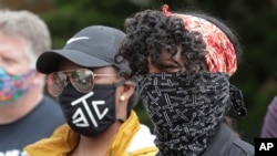 Protesters wear masks to help prevent the spread of the coronavirus, June 5, 2020, in Tacoma, Wash.