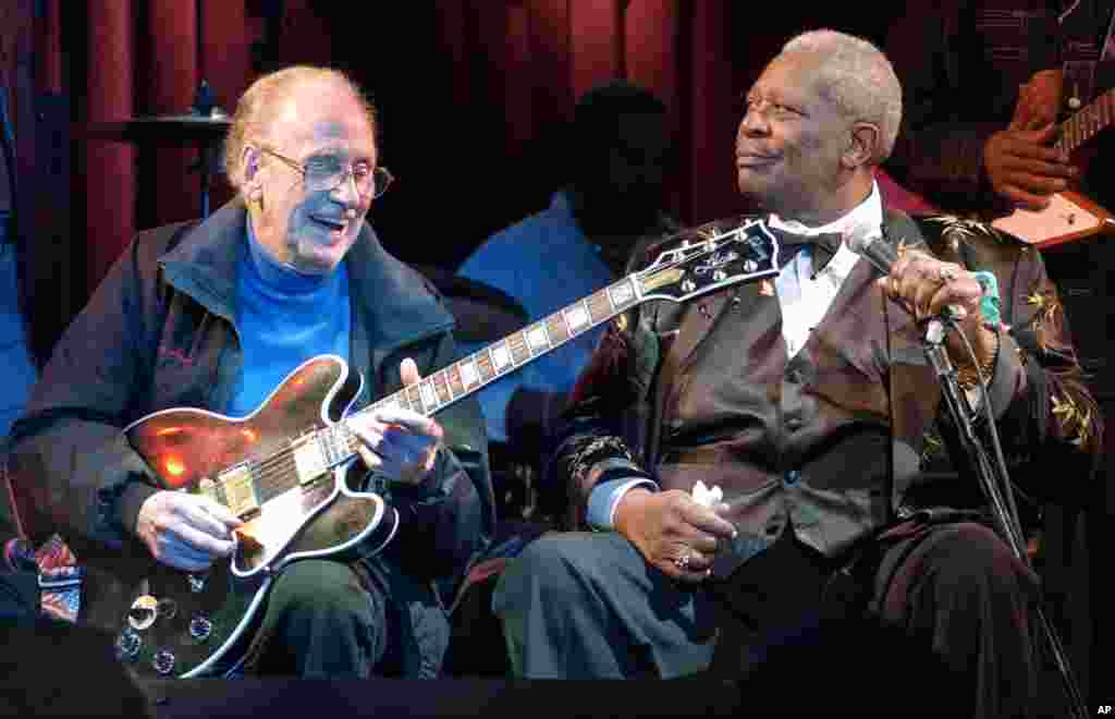 Blues legend B.B. King listens as electric guitar inventor Les Paul plays King's signature "Lucille" guitar during a jam session at the third anniversary celebration of the B.B. King Blues Club and Grill in New York's Times Square, June 17, 2003.