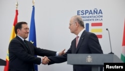 El Ministro de Asuntos Exteriores español, José Manuel Albares, y el Primer Ministro palestino, Mohammad Mustafa, se dan la mano durante una conferencia de prensa conjunta, en Bruselas, Bélgica, el 26 de mayo de 2024.