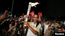 Model Adriana Lima carries the Olympic torch in Maua Square in Rio de Janeiro, Brazil, August 4, 2016. 