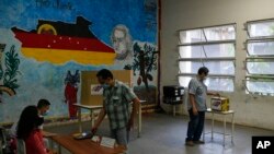 Un votante deposita su voto en un centro electoral durante las elecciones primarias del partido gobernante del Partido Socialista Unido de Venezuela en Caracas, el 8 de agosto de 2021.