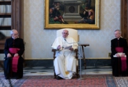 This handout photo taken and released on April 8, 2020 by the Vatican Media shows Pope Francis, center, speaking during a weekly live broadcast at The Vatican.