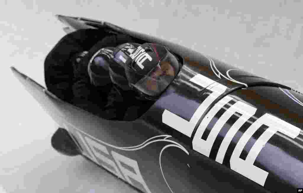 The team from the United States USA-1, piloted by Steven Holcomb, take a curve during the men's four-man bobsled training at the 2014 Winter Olympics, Feb. 21, 2014.
