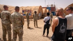 FILE - In this image by the U.S. Air Force, Maj. Gen. Kenneth P. Ekman speaks to military members in front of a "Welcome to Niamey" sign depicting U.S. military vehicles at Air Base 101 in Niger, May 30, 2024. 