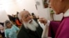 FILE - A priest gives communion host during a mass in a convent of Saint Germain en Laye, west of Paris.