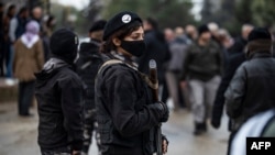 FILE - Members of Kurdish security forces known as Asayish stand guard in the northeastern Syrian city of Qamishli, Jan. 20, 2021.