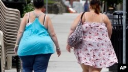 FILE - Two women cross the street in Barre, Vermont, June 17, 2013.