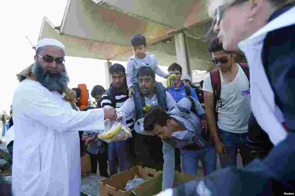 Migrants receive food as they arrive at a train station in Hegyeshalom, Hungary. Prime Minister Viktor Orban said he would propose to European Union leaders that the bloc&#39;s members boost payments to the EU budget by 1 percent and cut EU spending by 1 percent to help cope with the refugee crisis..