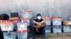 A polling agent sits next to ballot boxes as vote counting continues at various stations in Lusaka, Zambia, Aug. 13, 2021. 