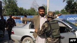 Petugas keamanan Afghanistan menggeledah pejalan kaki di titik pemeriksaan, Provinsi Kunduz.