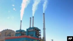 FILE - Smoke rises from the Colstrip Steam Electric Station, a coal burning power plant in in Colstrip, Montana.