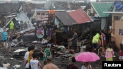 Residents stand among their damaged houses after Typhoon Kammuri hit Legazpi City, Albay, Philippines, Dec. 2, 2019.