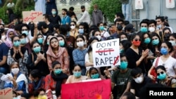 FILE - People carry signs against a gang rape that occurred along a highway and to condemn violence against women and girls, during a protest in Karachi, Pakistan, Sept. 12, 2020. 