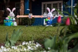 FILE - The owners of a house known for their seasonal decorations have put up a display combining Easter and coronavirus-related social distancing measures in their yard, seen April 1, 2020, in Washington, D.C.
