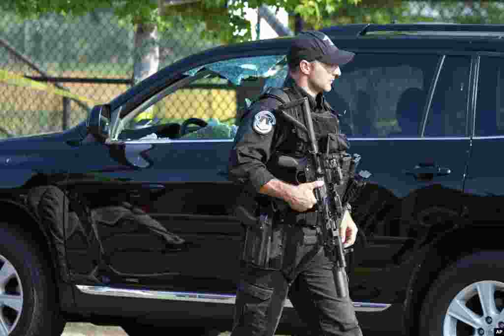 A Capitol Hill Police officer walks past an automobile with the driver&#39;s window damaged at the scene of a shooting in Alexandria, Virginia, where House Majority Whip Steve Scalise was shot, June 14, 2017.