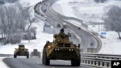 A convoy of Russian armored vehicles moves along a highway in Crimea, Jan. 18, 2022.