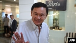 FILES - Thailand's former prime minister Thaksin Shinawatra waves as he walks out from a beauty salon in Bangkok on June 5, 2024.