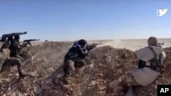 FILE - This frame grab from a video provided by the Syria Democratic Forces shows fighters from the SDF opening fire on an Islamic State group's position, in Raqqa's eastern countryside, Syria, March 6, 2017.