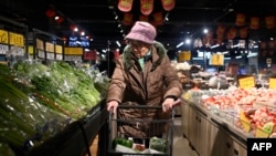 A woman selects vegetables at a supermarket in Beijing, on Jan. 9, 2025.