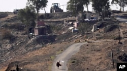 A Syrian man waves a white flag as he approaches Israeli soldiers to negotiate with them, where they set their new position at an abandoned Syrian military base, in Maariyah village near the border with Israel in southern Syria, Dec. 19, 2024.