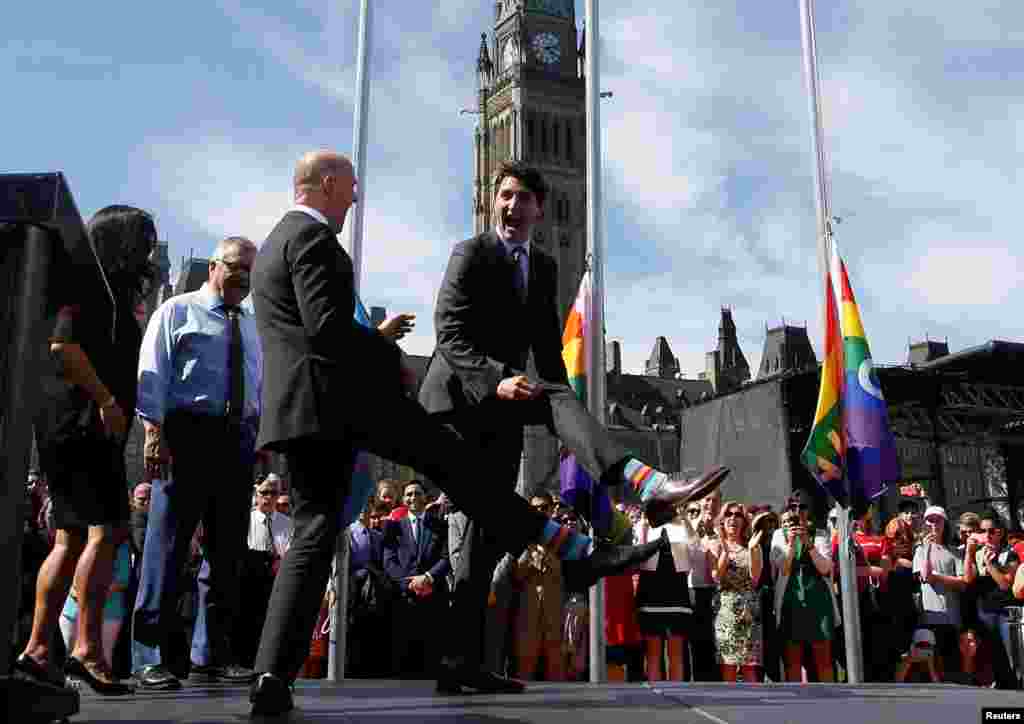 Canada&#39;s Prime Minister Justin Trudeau (R) compares socks with Liberal MP Randy Boissonnault during a pride flag raising ceremony on Parliament Hill in Ottawa, Ontario, June 14, 2017.