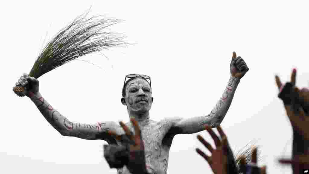 'Yan Najeriya dauke da tsintsiya da ruwa, Kaduna, Afrilu 1, 2015.