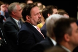 Radio host Sebastian Gorka listens as President Donald Trump speaks during the Social Media Summit in the East Room of the White House, July 11, 2019.