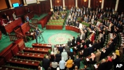 New Tunisian National Assembly parliement members stand during the first session of the chamber, Wednesday Nov.13, 2019 in Tunis. Tunisia's new parliament opened with a session to elect a speaker after last month's election. 