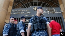 Police officers stand guard outside the building of the Lebanese Association of Banks after anti-government protesters locked the main entrance with a chain during ongoing protests against the banks and the government, in Beirut, Lebanon, Nov. 1, 2019.
