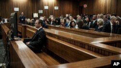 Oscar Pistorius, front left, listens to evidence in court in Pretoria, South Africa, June 30, 2014. 