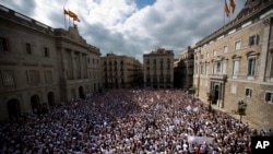 People gather during a protest in favor of talks and dialogue in Sant Jaume square in Barcelona, Spain, Saturday Oct. 7, 2017. Thousands gathered at simultaneous rallies in Madrid and Barcelona in a call for dialogue amid a political crisis caused by Catalonia's secession push. 