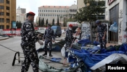 Lebanese security forces pull down tents as they clear away a protest camp and reopened roads blocked by demonstrators since protests against the governing elite started in October, in Beirut, Lebanon, March 28, 2020. 