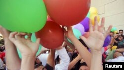 Egyptians attempt to catch balloons released after Eid al-Fitr prayers, marking the end of the Muslim holy fasting month of Ramadan, at a public park outside El-Seddik Mosque in Cairo, Egypt, June 15, 2018.