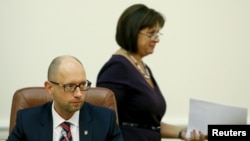 Ukrainian Finance Minister Natalia Yaresko (R) walks past Prime Minister Arseny Yatseniuk during a government meeting in Kiev, Aug. 27, 2015. 