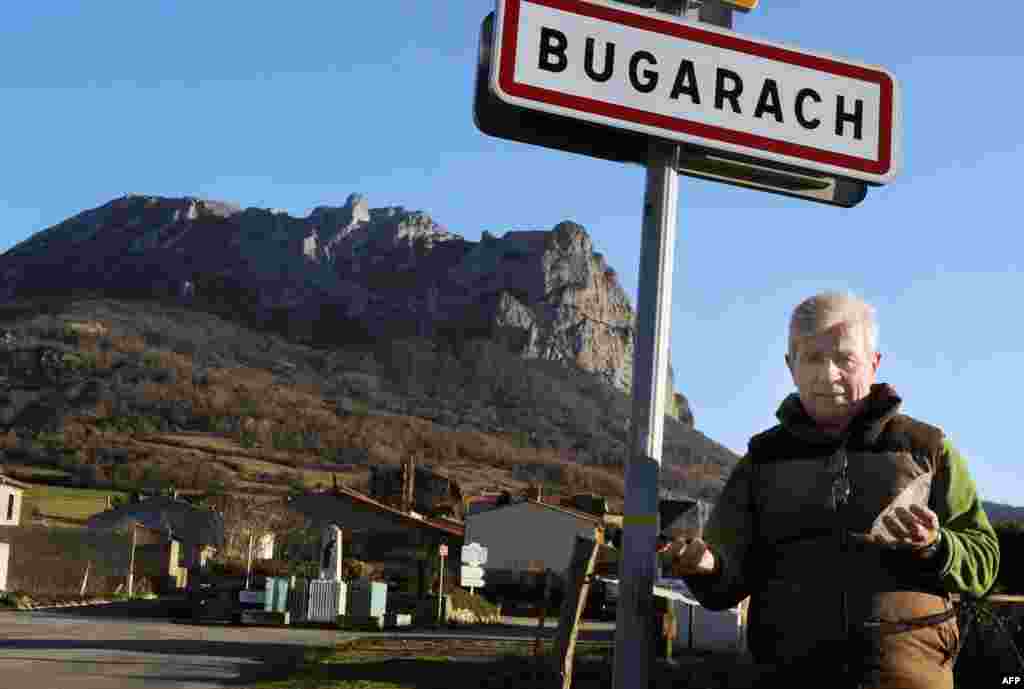 Bugarach Mayor Jean-Pierre Delord poses in front of a road sign, Dec. 14, 2010. 