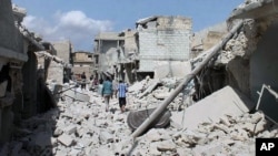 Puing-puing rumah-rumah menyusul serangan udara pemerintah Suriah di Aleppo, Suriah (27/9). (AP/Syrian Observatory for Human Rights)