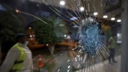 FILE - Saudi airport personnel are pictured behind shrapnel-riddled glass at Abha airport in the southwest of Saudi Arabia, August 31, 2021.