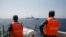 Officers of the Vietnamese Marine Guard monitor a Chinese coast guard vessel (top) on the South China Sea, about 210 km (130 miles) offshore of Vietnam, May 15, 2014.